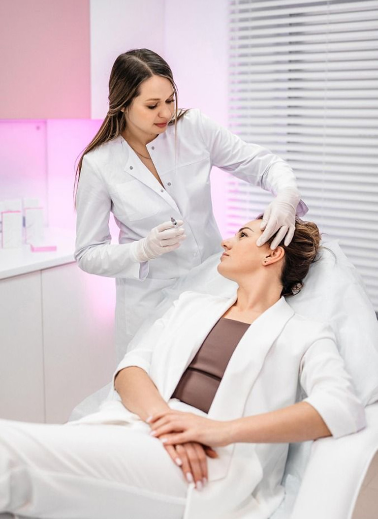 Especialista atiende a una mujer en consultorio de medicina estética