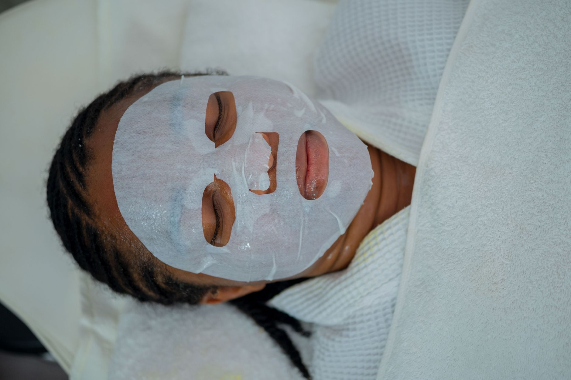 Mujer con mascarilla facial durante un tratamiento estético
